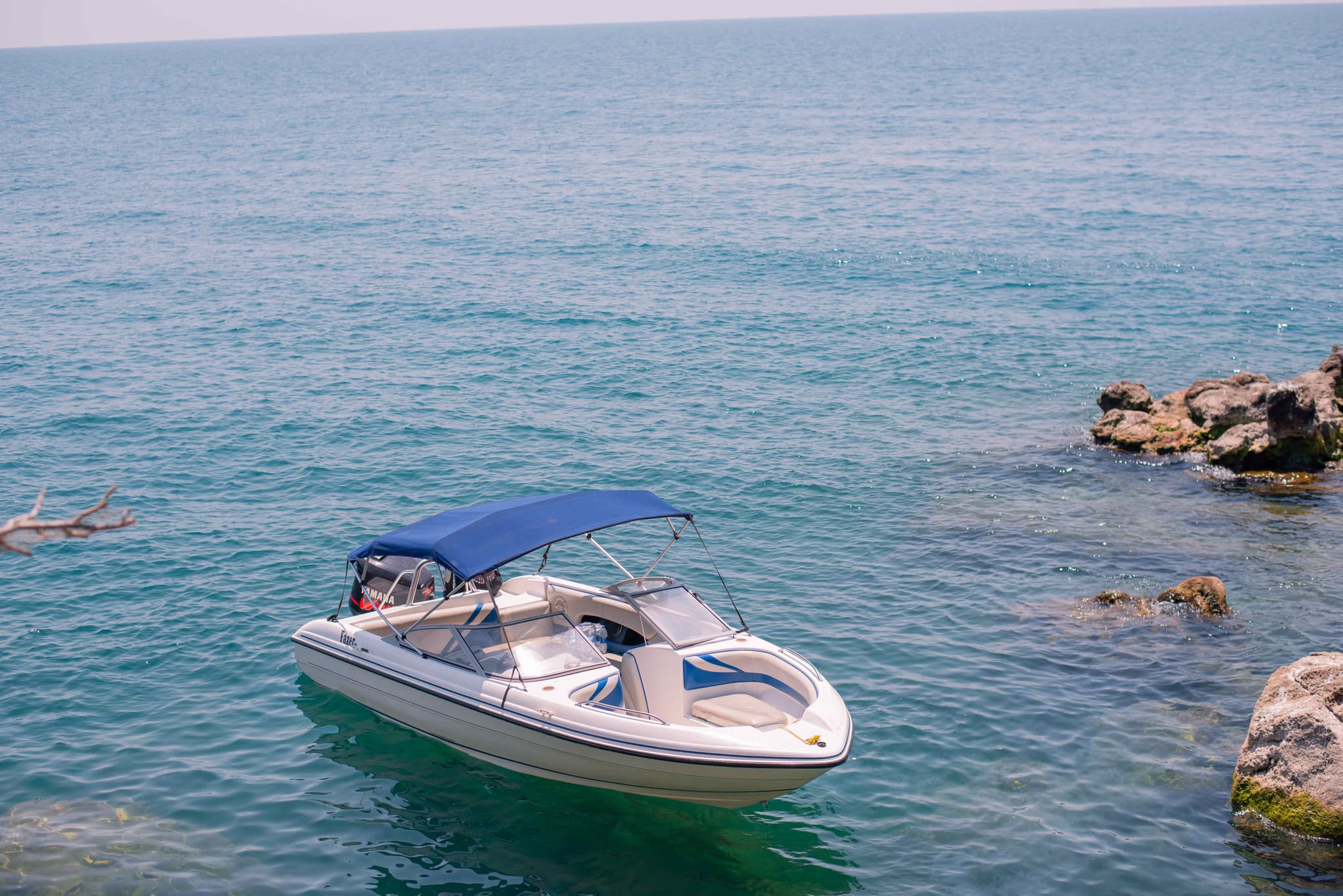 White and blue speedboat floating on the clear waters of Lake Malawi